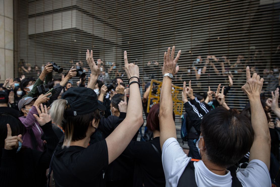 Pro-democracy activists gesture in support of arrested activists outside the West Kowloon Court in Hong Kong on Monday.