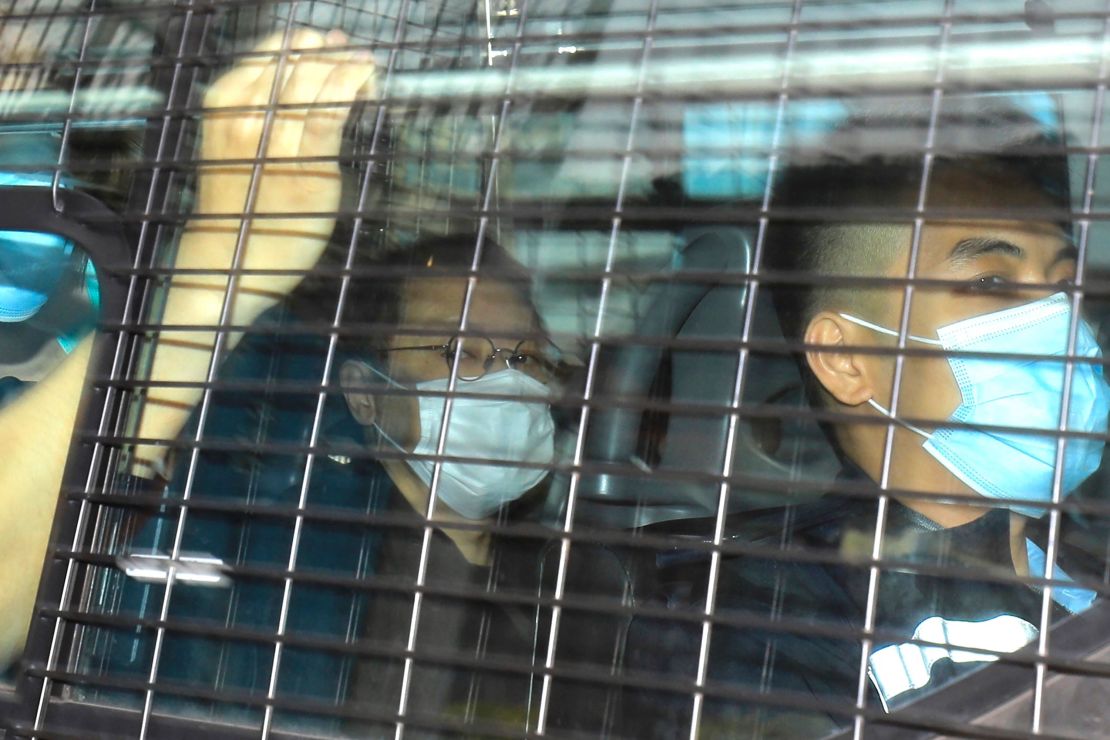 Former law professor Benny Tai, left, arrives to court in a police van on Monday.