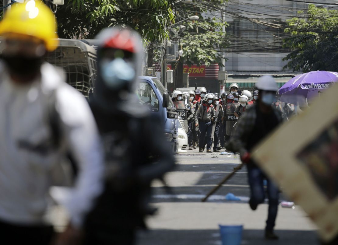 Protesters flee from anti-riot police officers during an anti-coup protest following the military crackdown in Yangon, on March 1.
