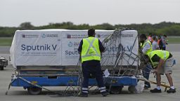 Airport workers transport shipping containers with Sputnik V vaccine doses against COVID-19, at the Ezeiza International Airport in Buenos Aires, on February 12, 2021. - A shipment with 400,000 Sputnik V vaccine doses arrived in Argentina, in what represents the fourth delivery for the South American country from the Russian laboratory Gamaleya. Argentina crossed the barrier of 2 million infected on February 10, since the first case detected in March 3, 2020. (Photo by JUAN MABROMATA / AFP) (Photo by JUAN MABROMATA/AFP via Getty Images)