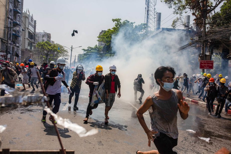 Protesters in Yangon run away from tear gas on March 1.