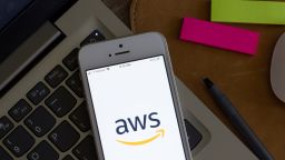 AWS management console mobile app welcome page is seen on a smartphone. AWS is a subsidiary of Amazon that provides on-demand cloud computing platforms and APIs.