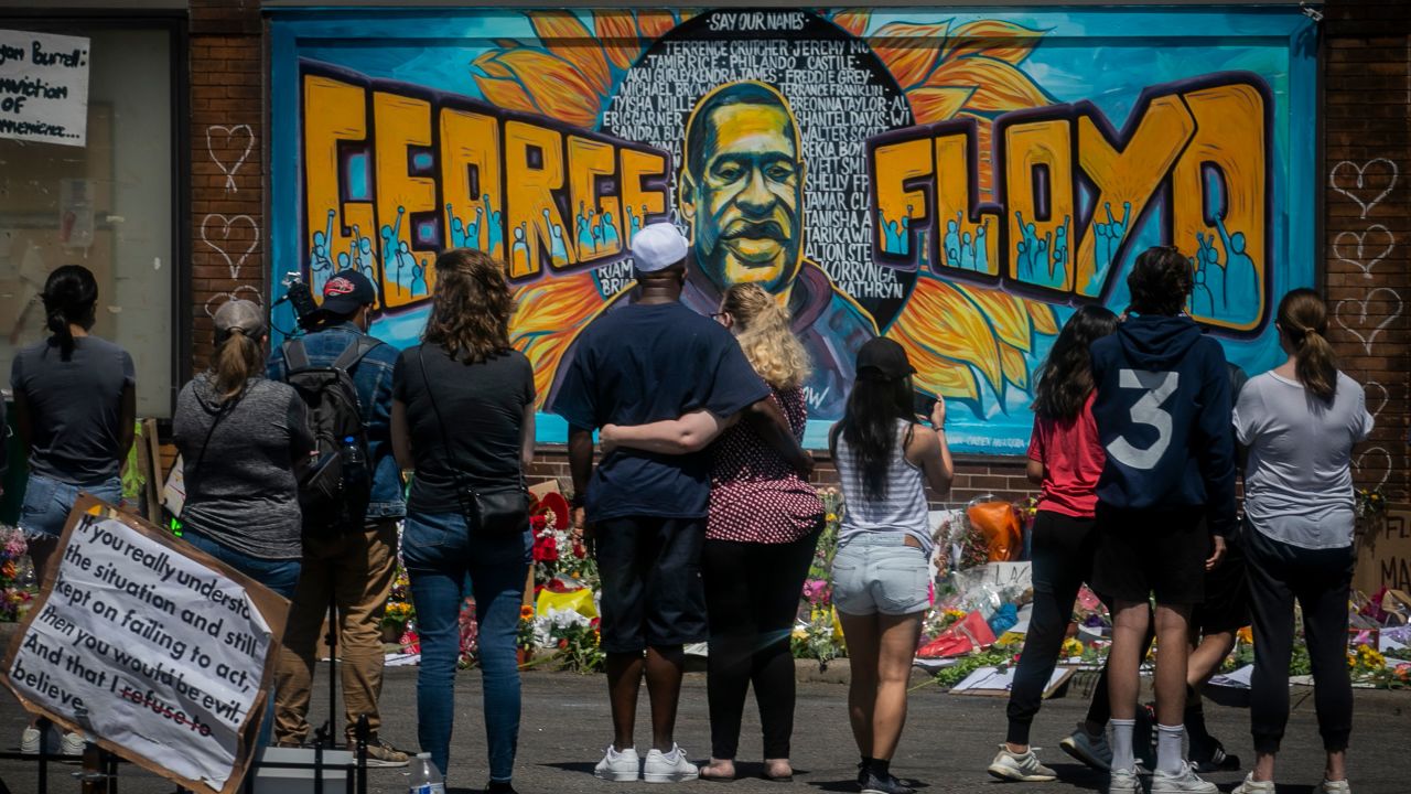 On May 31, mourners visit a memorial featuring a mural of George Floyd, near the spot where he died while in police custody.