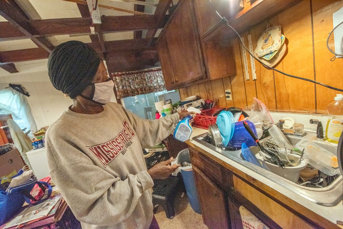 Paula Conley, who lives in West Jackson, sprays disinfectant on dishes that she hasn't yet washed because of the water shortage.