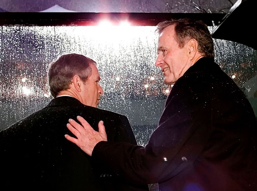 Bush gets a pat on the back from his dad during his inauguration ceremonies.