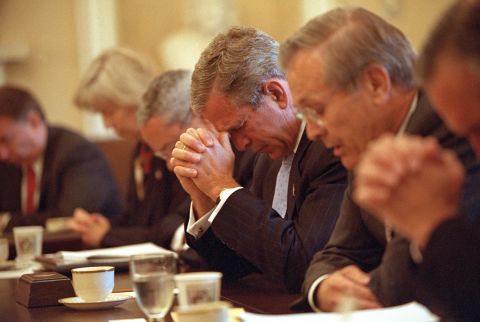 Bush and his Cabinet bow their heads in prayer before a White House meeting on September 14, 2001.