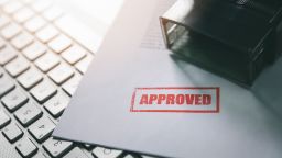 underscored red approval stamp on documents