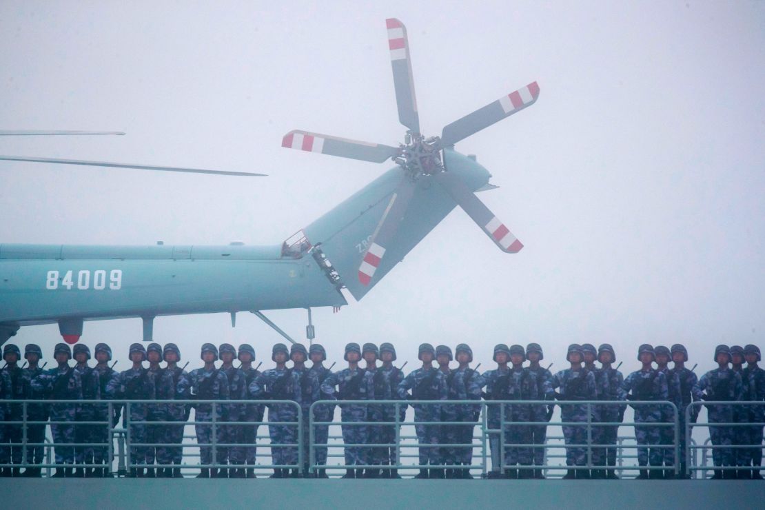 Soldiers stand on deck of the ambitious transport dock Yimen Shan of the PLA Navy as it participates in a parade in the sea near Qingdao, China, in 2019. 