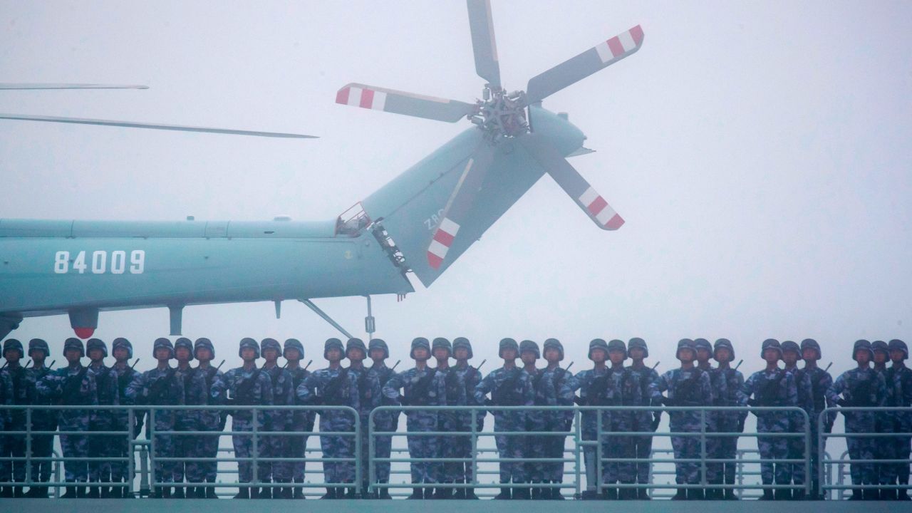 Soldiers stand on deck of the ambitious transport dock Yimen Shan of the PLA Navy as it participates in a parade in the sea near Qingdao, China, in 2019.