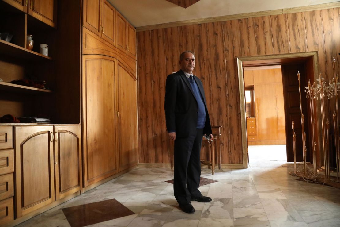 Deacon Louis Climis stands in Our Lady of Salvation Church's sacristy where dozens took cover, and perished, as terrorists laid siege to the church in 2010. The deacon and his son, along with dozens of other worshipers, took cover in this room during the massacre. 