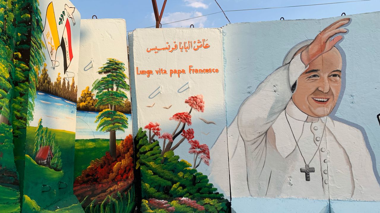 Blast walls which continue to surround the Our Lady of Salvation church are adorned with murals of Pope Francis in preparation for the historic papal visit.