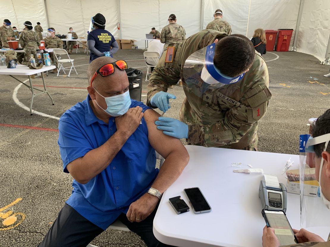 Guillermo Muñoz, a school principal in Miami-Dade County, receives a Johnson & Johnson vaccine shot Wednesday at a FEMA-run site at Miami Dade College.