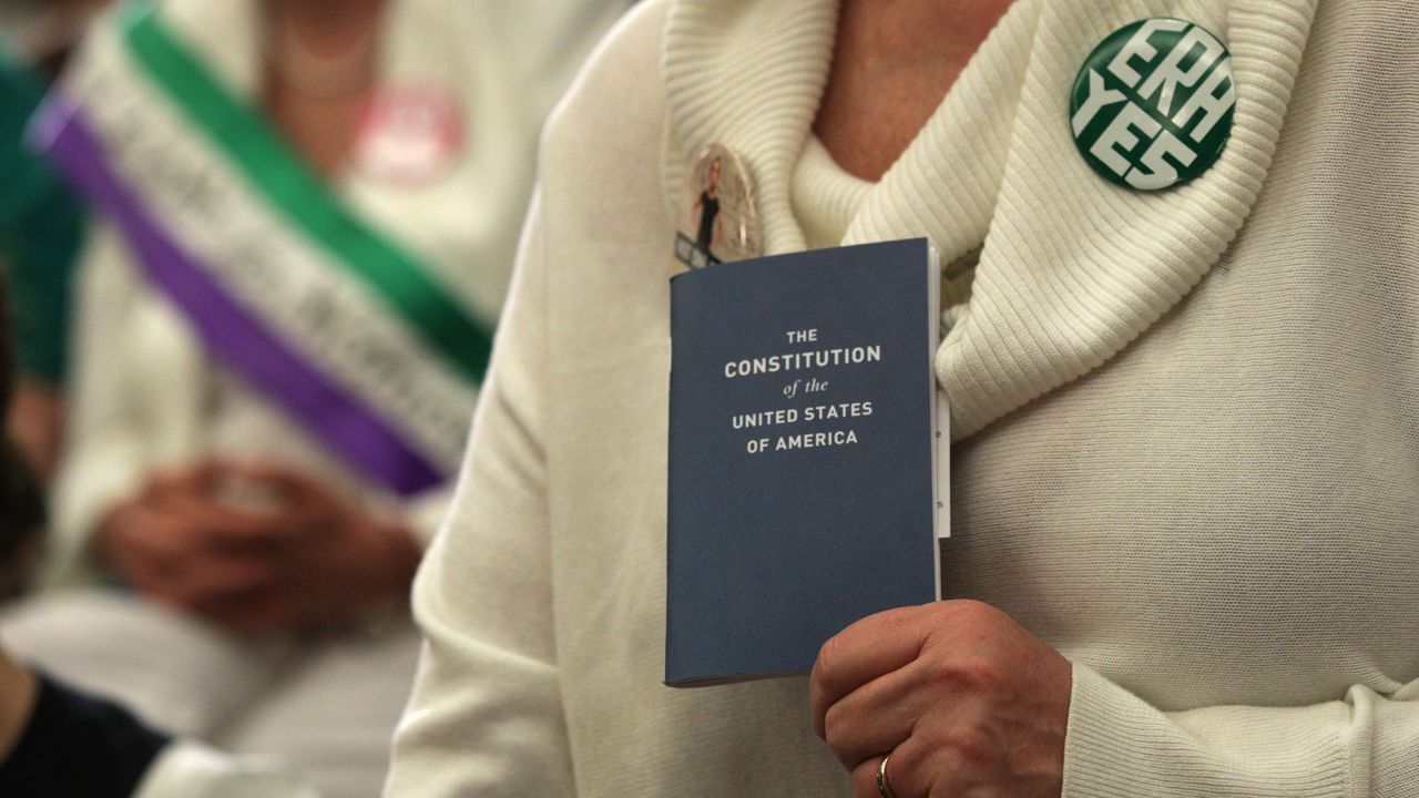 An activist holds a copy of the U.S. Constitution during a news conference on women's rights April 30, 2019 on Capitol Hill in Washington, DC.