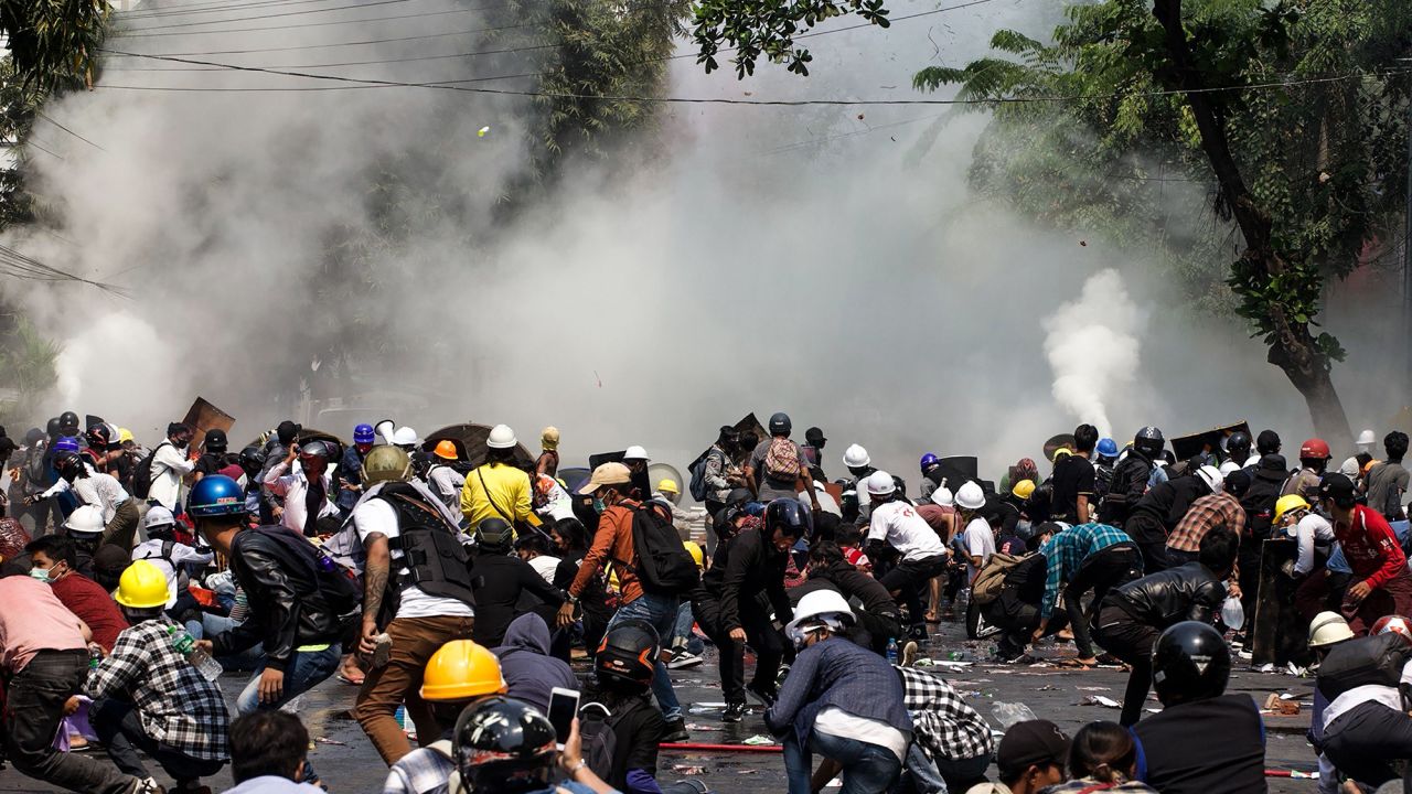 Protesters run from police firing tear gas during a pro-democracy demonstration in Mandalay, Myanmar, on Wednesday.