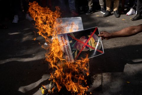 A citizen of Myanmar living in India burns a poster of Myanmar's military chief during a protest in New Delhi on March 3.