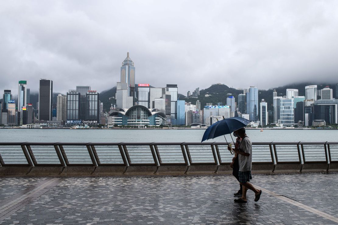 Two pedestrians using umbrellas on Kowloon's Tsim Sha Tsui waterfront after Typhoon Higos swept Hong Kong overnight on Aug. 19, 2020. 