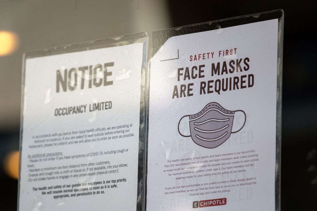 Signs about coronavirus restrictions hang outside of Chipotle in Austin, Texas on March 3, 2021.