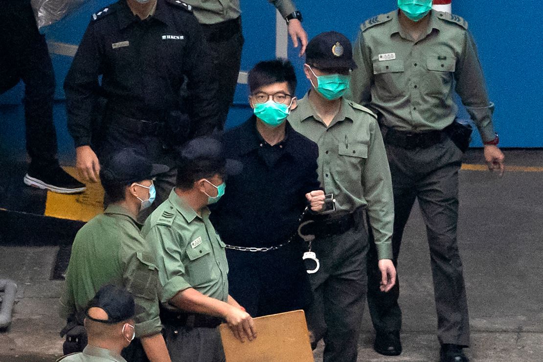 Hong Kong activist Joshua Wong, one of the 47 pro-democracy activists, is escorted by Correctional Services officers to a prison van in Hong Kong on Thursday.