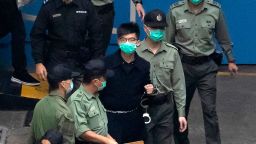 Hong Kong activist Joshua Wong, one of the 47 pro-democracy activists is escorted by Correctional Services officers to a prison van in Hong Kong, Thursday, March 4, 2021. A marathon court hearing for 47 pro-democracy activists in Hong Kong charged with conspiracy to commit subversion enters its fourth day on Thursday, as the court deliberates over whether the defendants will be granted bail. (AP Photo/Kin Cheung)