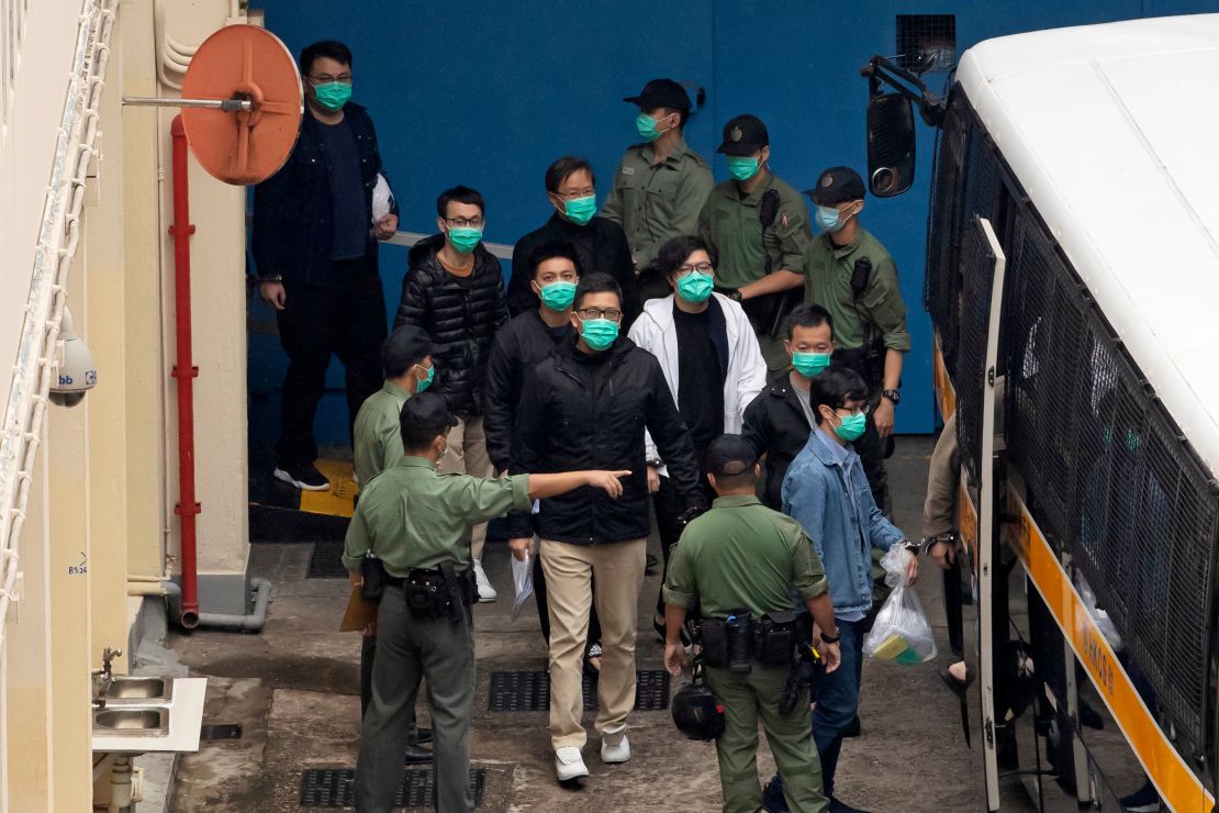 Some of the 47 pro-democracy activists, including Lam Cheuk-ting, center, are escorted by Correctional Services officers to a prison van on Thursday.