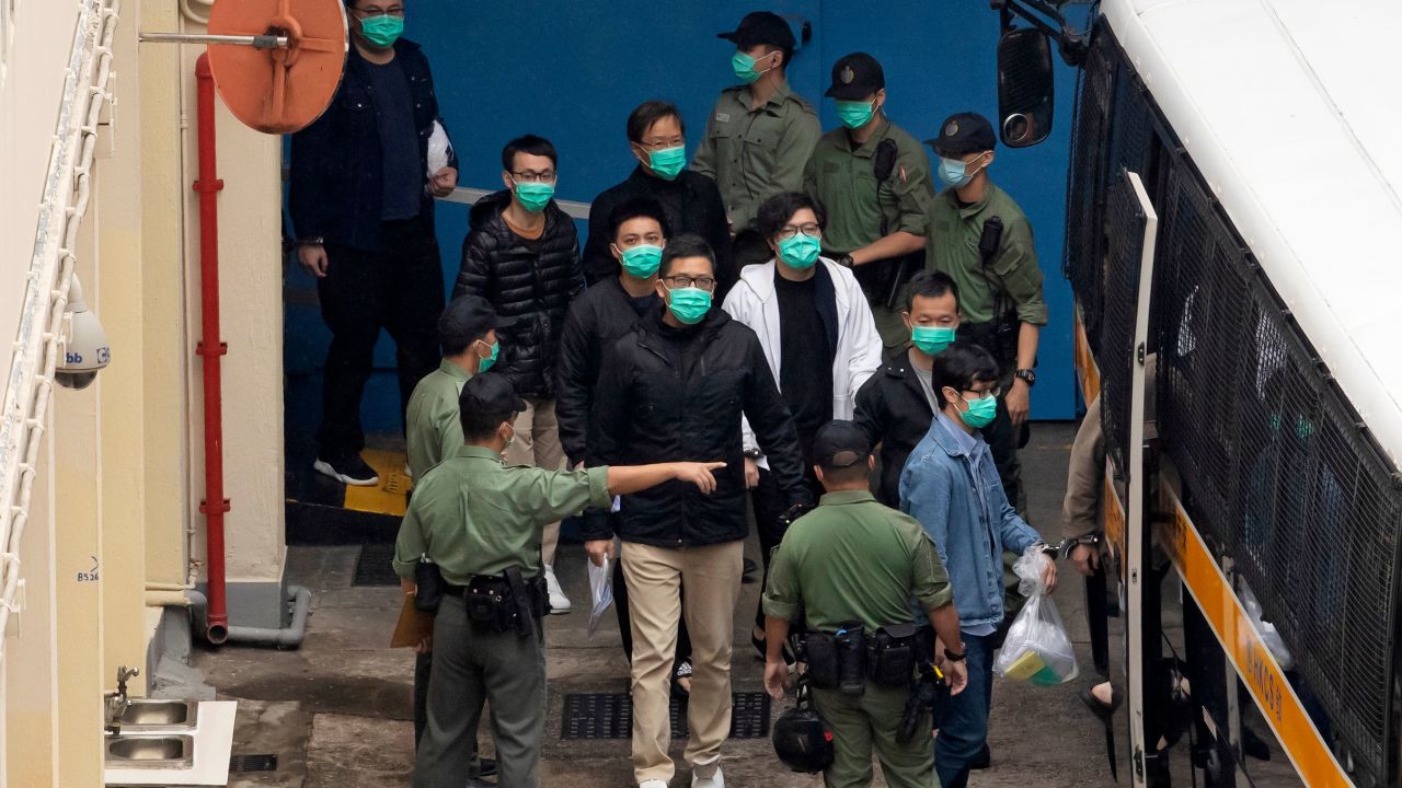 Some of the 47 pro-democracy activists, including Lam Cheuk-ting, center, are escorted by Correctional Services officers to a prison van on Thursday.