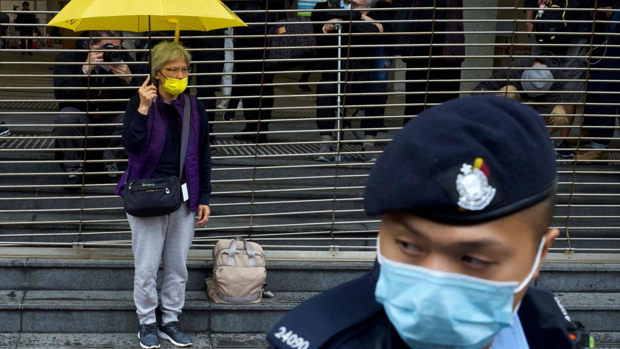 A pro-democracy supporter holding an umbrella queues up for the hearing outside the courthouse in Hong Kong on Thursday.