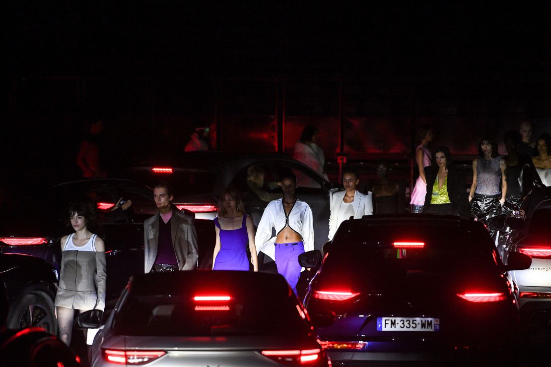 Models walk between rows of cars at Coperni's autumn-winter 2021 show, staged at the AccorHotels Arena in Paris.