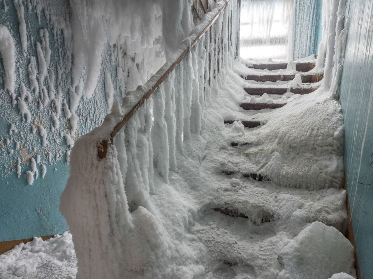 A staircase is frozen inside an abandoned building in the village of Severny.