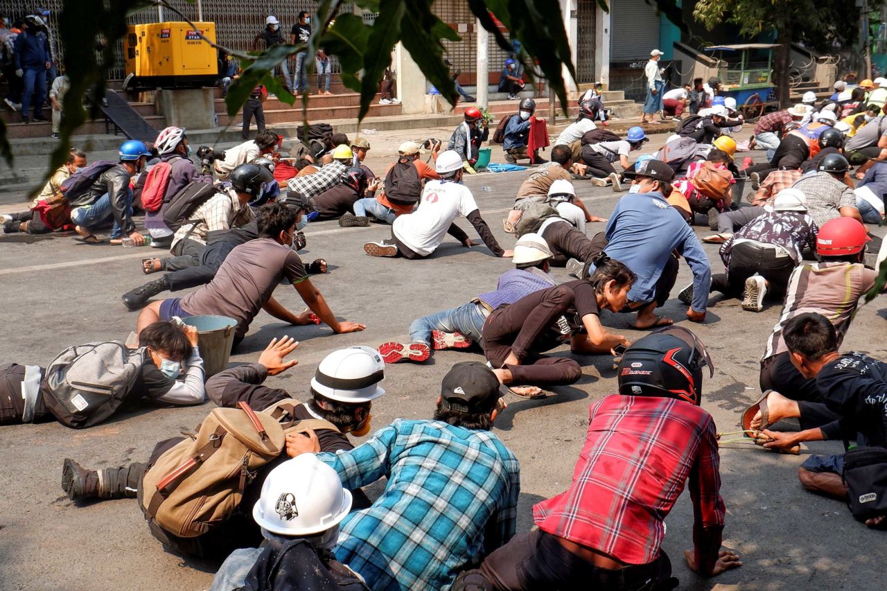 Protesters lie on the ground after police opened fire to disperse an anti-coup demonstration in Mandalay on March 3.