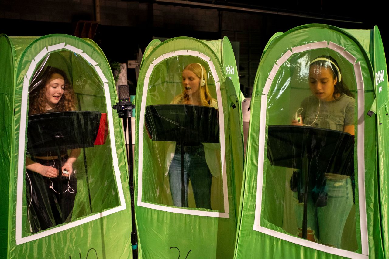 From left, high school students Emma Banker, Jessi McIrvin and Valerie Sanchez record their vocals in pop-up tents during a choir class in Wenatchee, Washington, on Friday, February 26. Wenatchee High School has been using the tents for its music programs during the Covid-19 pandemic.