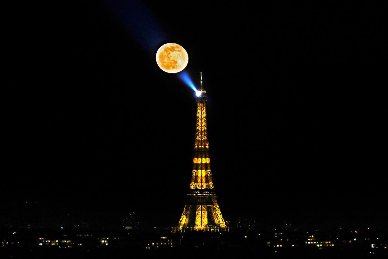 A full moon appears behind the Eiffel Tower in Paris on Sunday, February 28.