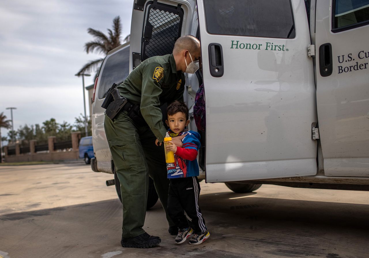 A US Border Patrol agent delivers a young migrant and his family to a bus station in Brownsville, Texas, on Friday, February 26.