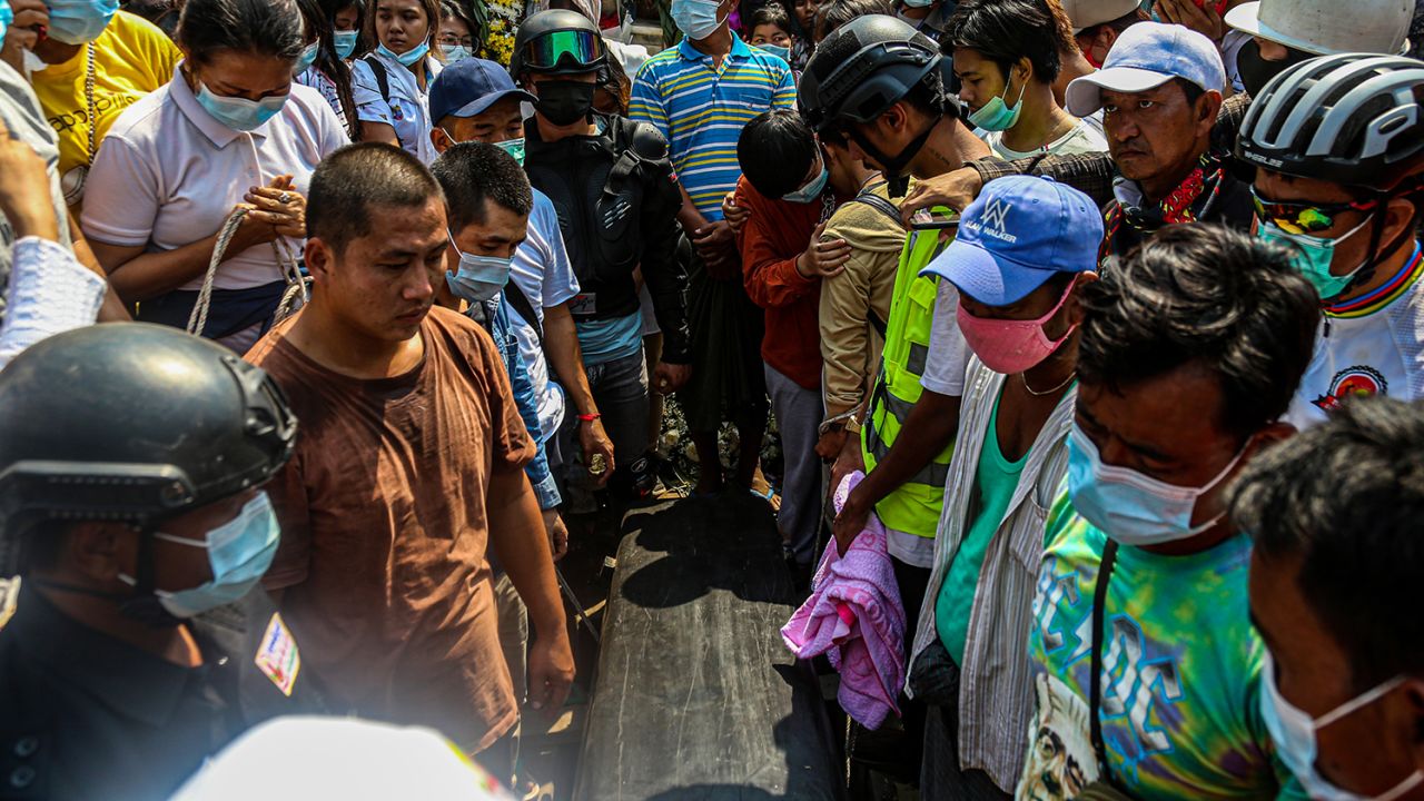 People stand next to Ma Kyal Sin's coffin during her funeral ceremony.