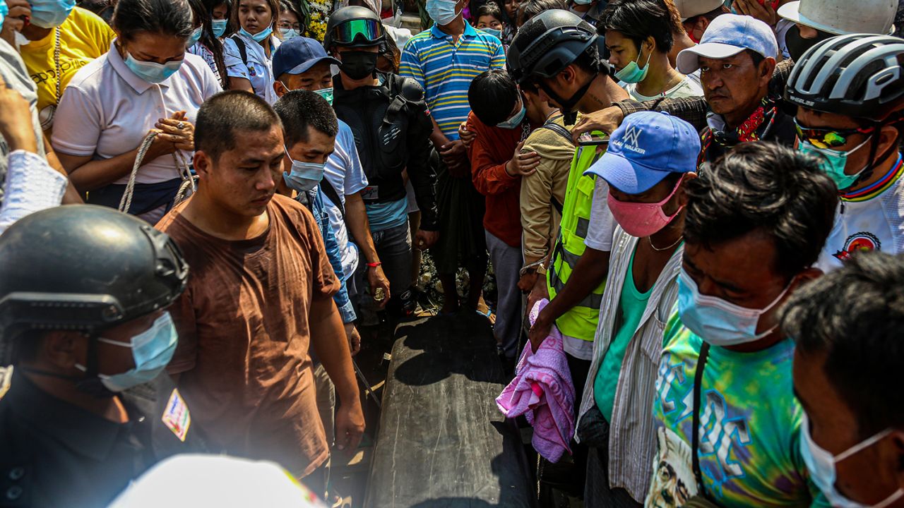 People stand next to Ma Kyal Sin's coffin during her funeral ceremony.