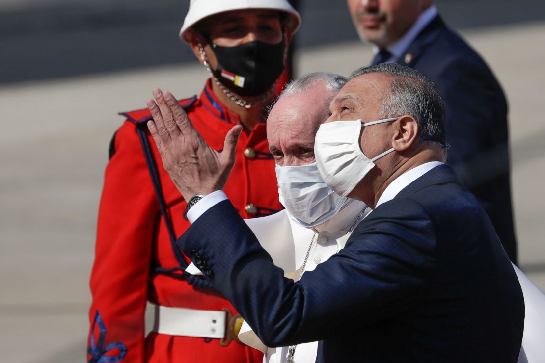 Pope Francis is greeted by Iraqi Prime Minister Mustafa al-Kadhimi as he arrives at Baghdad's international airport.