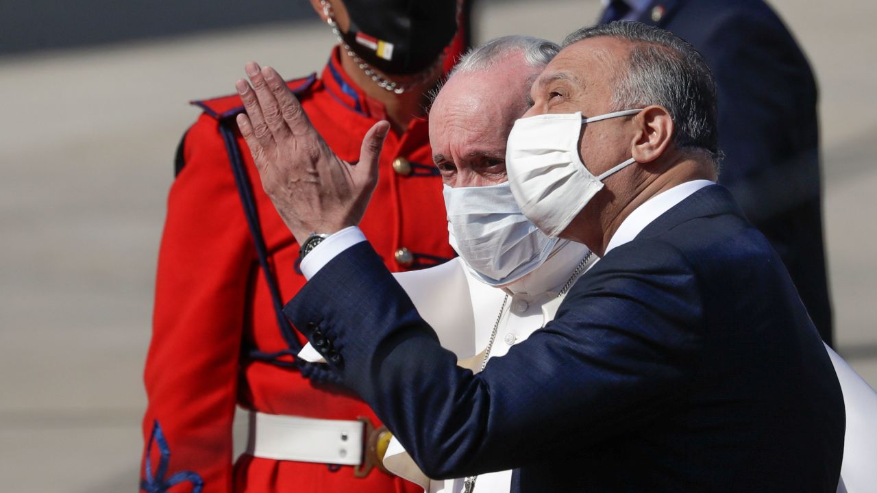 Pope Francis is greeted by Iraqi Prime Minister Mustafa al-Kadhimi as he arrives at Baghdad's international airport.