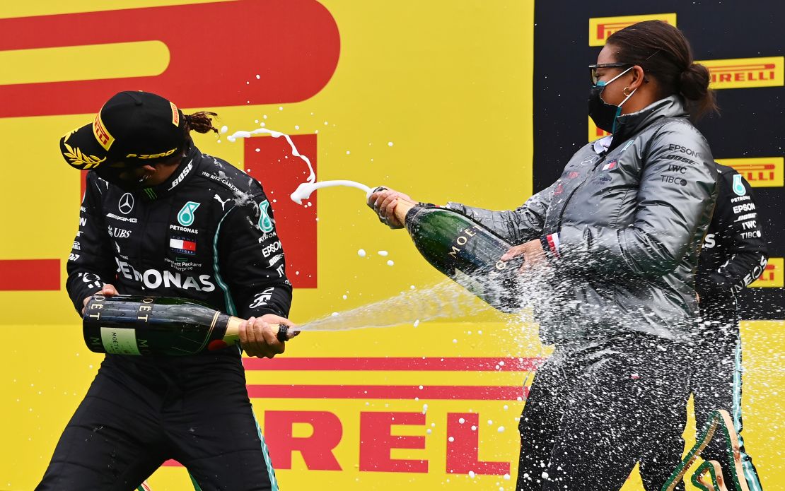Lewis Hamilton and Stephanie Travers celebrate on the podium after the Styrian Grand Prix.