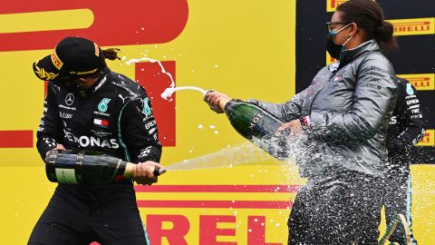 Lewis Hamilton and Stephanie Travers celebrate on the podium after the Styrian Grand Prix.