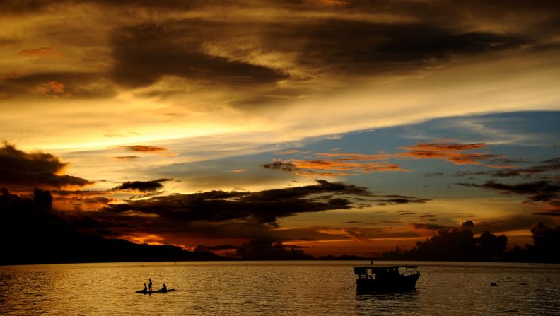 <strong>Flores sunsets: </strong>Fishermen paddle a traditional boat during sunset at Waiara beach in Maumere on the island of Flores. 