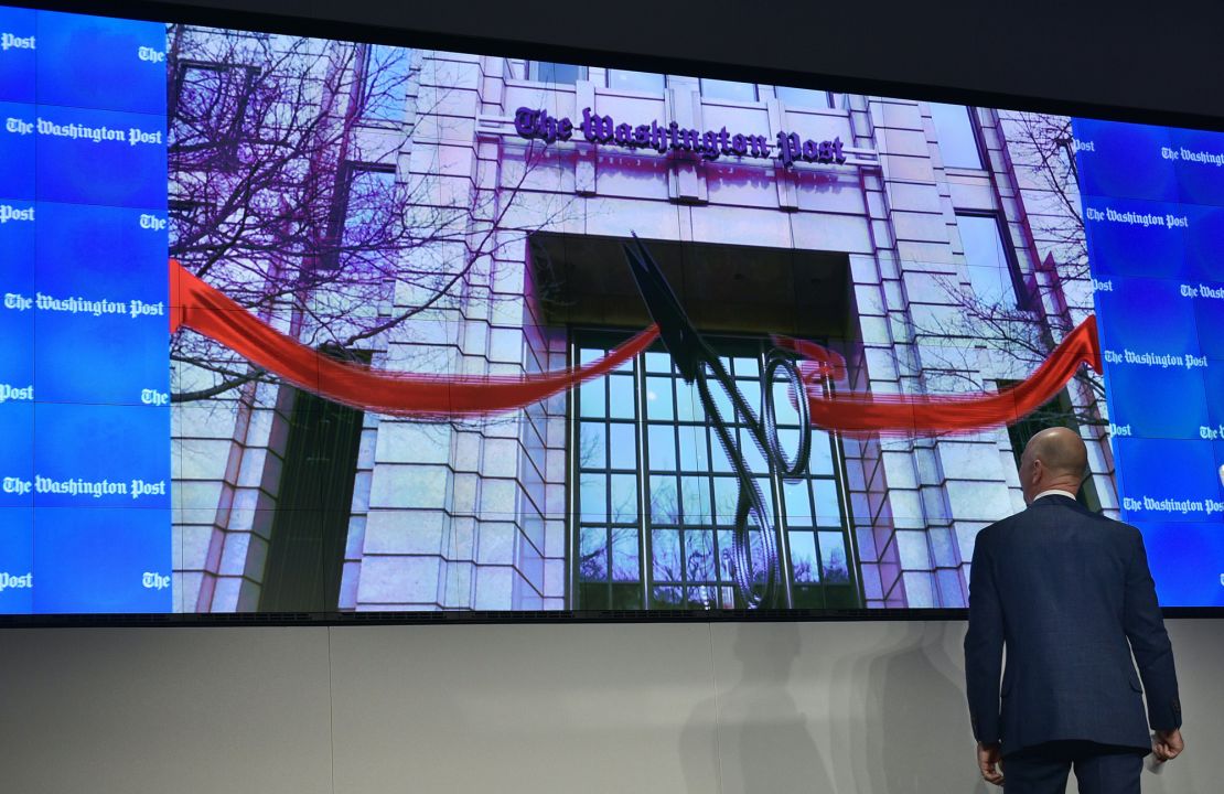 Washington Post owner Jeff Bezos takes part in a "digital ribbon cutting" during the inauguration of the Washington Post Headquarters on January 28, 2016 in Washington, DC. 
