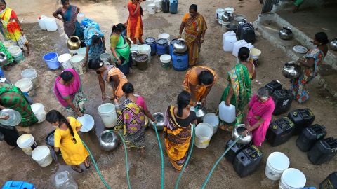 Indian women gather with utensils to collect water from a mobile water tanker at a slum area in Hyderabad, India, Wednesday, May 15, 2019. There is no direct supply of potable water at homes in most of the poor neighborhoods in the country. 