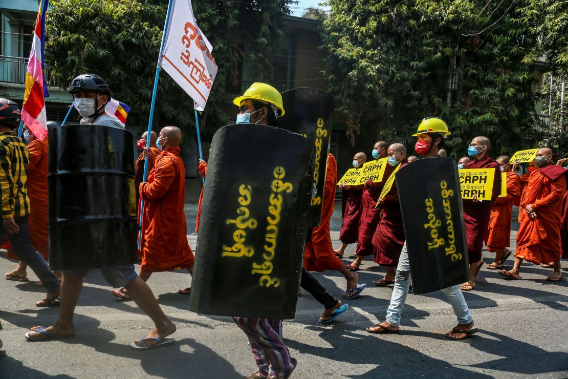 Demonstrators carry placards and makeshift shields during a protest against the military coup in Mandalay, Myanmar, March 7.