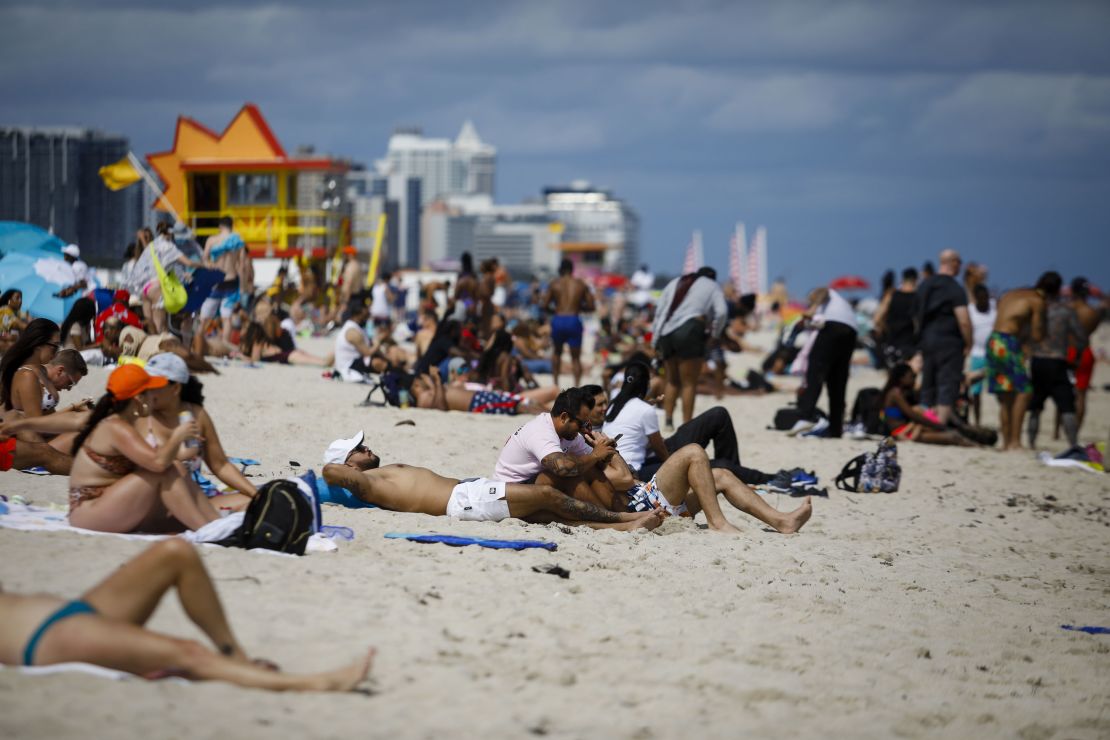 People gather Saturday on a beach in Miami.