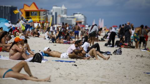People gather Saturday on a beach in Miami.