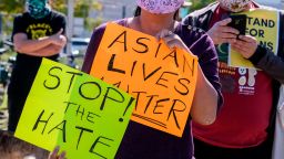 Demonstrators wearing face masks and holding signs take part in a rally to raise awareness of anti-Asian violence, near Chinatown in Los Angeles, California, on February 20, 2021. 