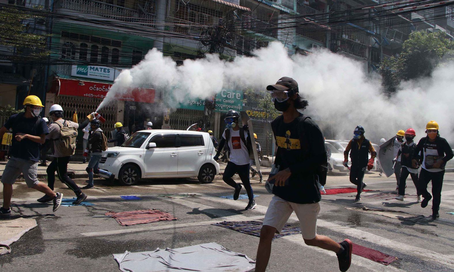 A protester discharges a fire extinguisher to counter the impact of tear gas that was fired by police in Yangon on March 8.
