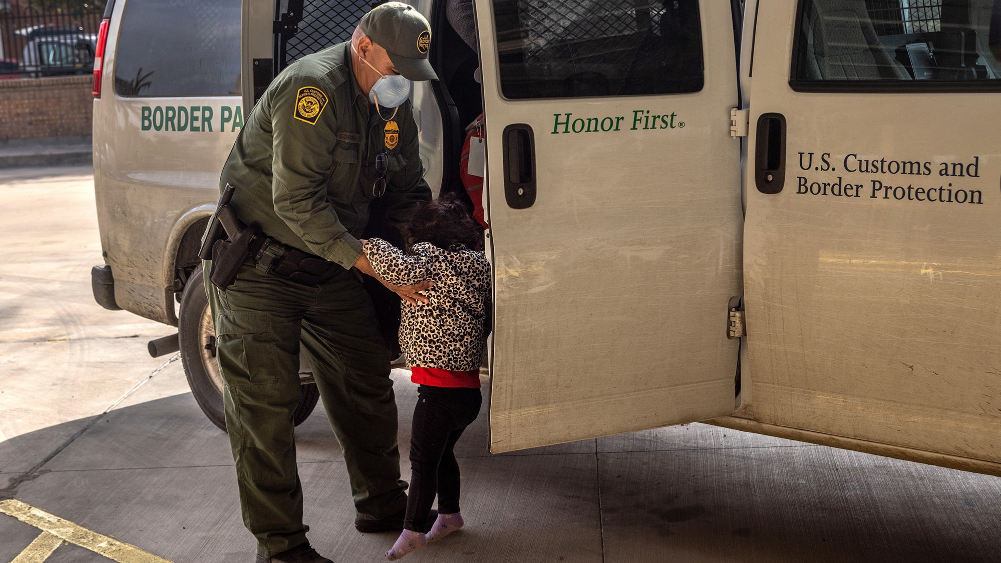 A US Border Patrol agent releases a young asylum seeker with her family at a bus station on February 25, 2021 in Brownsville, Texas. 