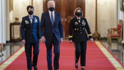 U.S. President Joe Biden, center, arrives with General Jacqueline Van Ovost, commander of the U.S. Transportation Command nominee for U.S. President Joe Biden, left, and Lieutenant General Laura Richardson, commander of the U.S. Southern Command nominee for U.S. President Joe Biden, during an event in the State Dining Room of the White House in Washington, D.C., U.S., on Monday, March 8, 2021. Biden vowed an 'all hands on deck effort' to combat sexual assault in the military during an International Women Day's event on Monday, where he appointed two women as four-star generals. Photographer: Kevin Dietsch/UPI/Bloomberg via Getty Images
