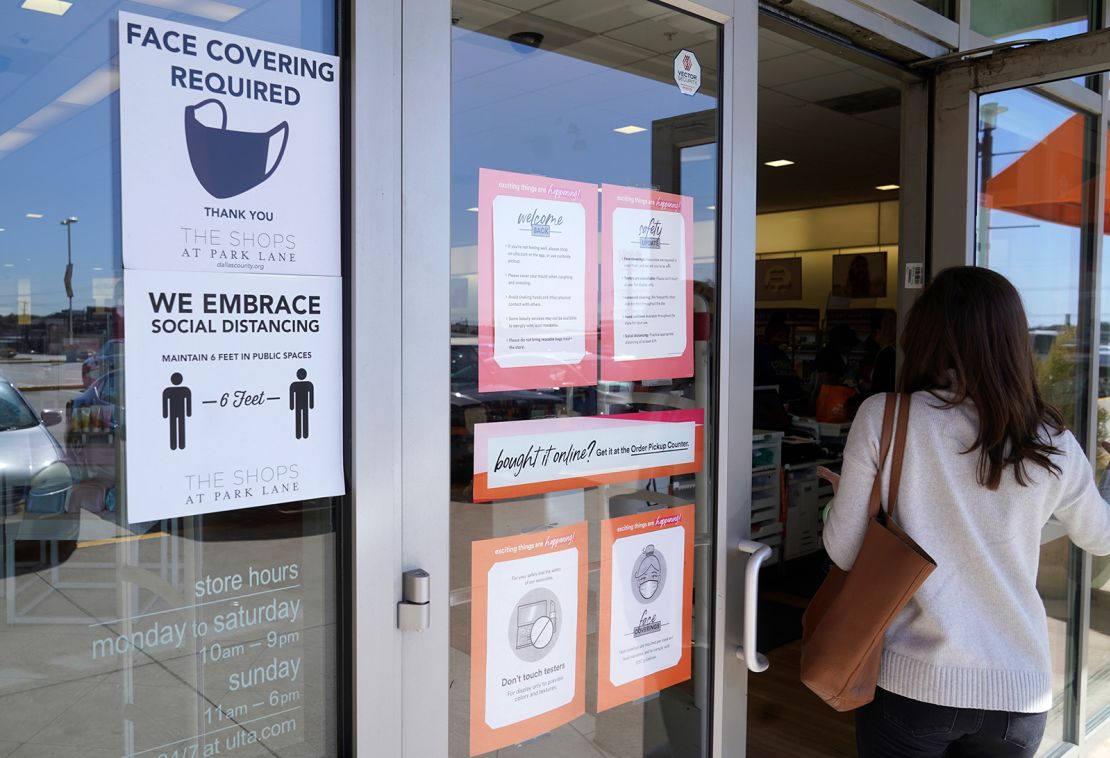 A customer enters a store with a face mask required sign displayed on March 2, 2021, in Dallas