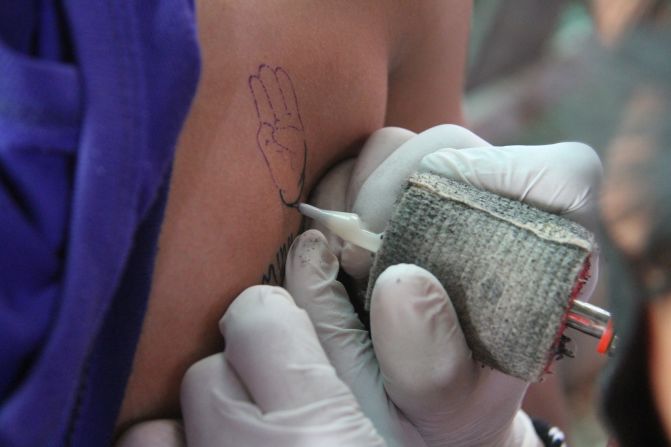 The three-finger salute, a popular symbol used by protesters in Myanmar and neighboring Thailand, was also tattooed onto participants.